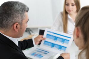 Profissionais segurando gráfico de crescimento, simbolizando o impacto positivo da terceirização para pequenas empresas.